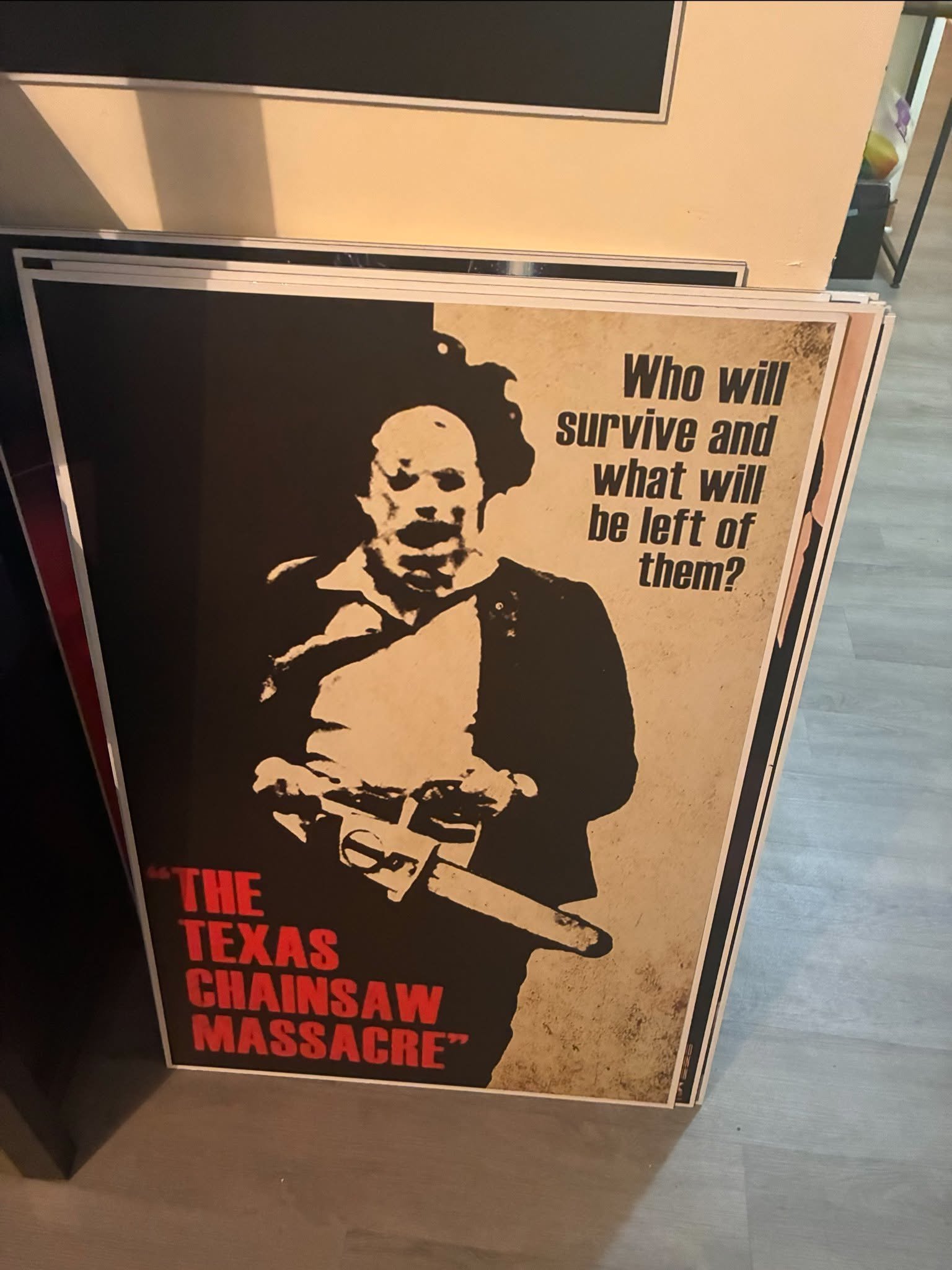 Photo of a Texas Chainsaw Massacre poster print with Leatherface revving the chainsaw in black, white, and blood red