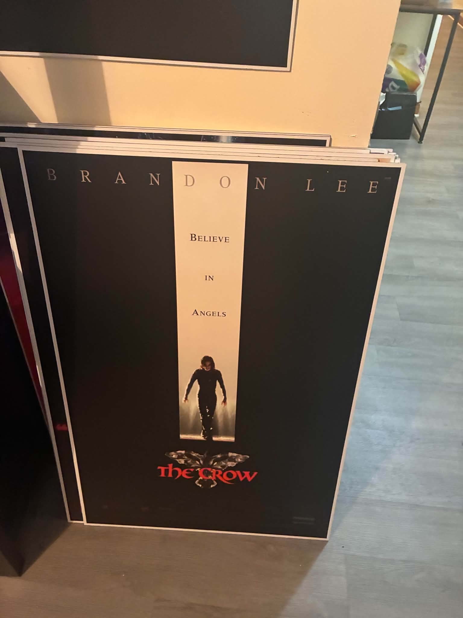 Photo of a The Crow poster print with Brandon Lee as Eric Draven walking through a beam of light on a black background